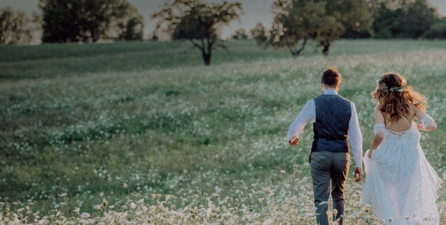bride-and-groom-walking-through-a-field