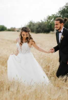 couple-frolicking-in-the-meadow-on-their-wedding-day