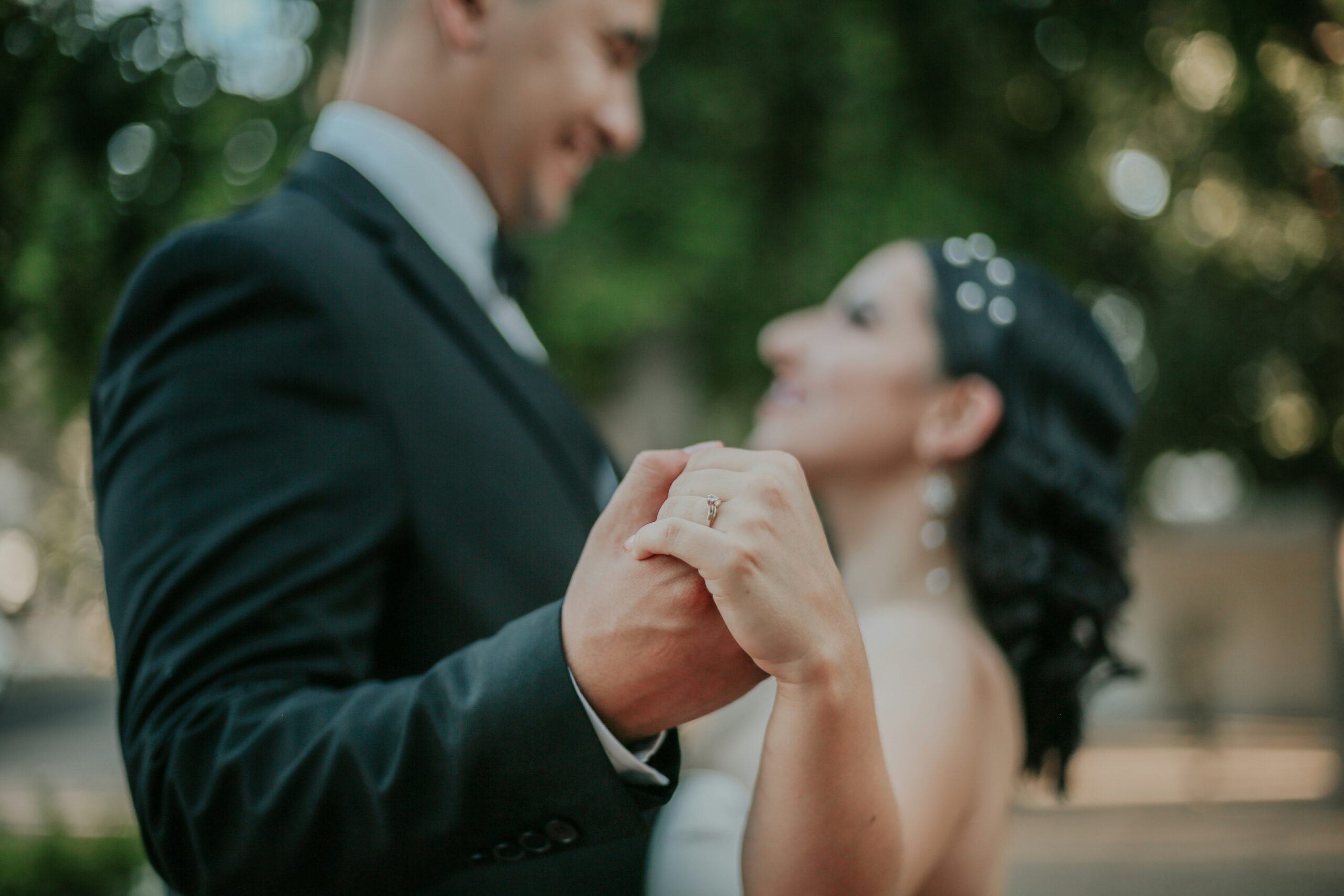 a bride and groom holding hands and smiling at each other