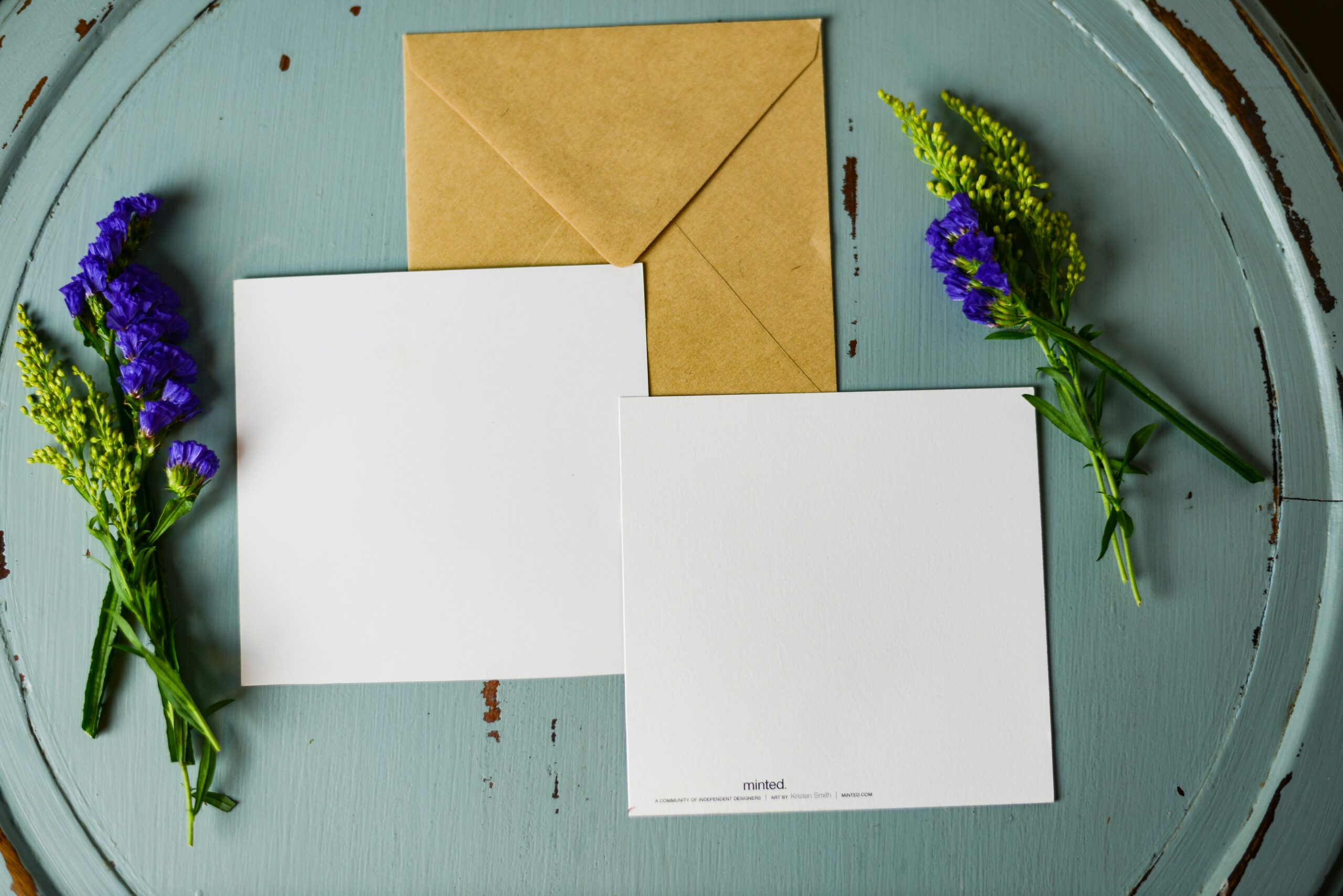 envelope and card next to purple flowers