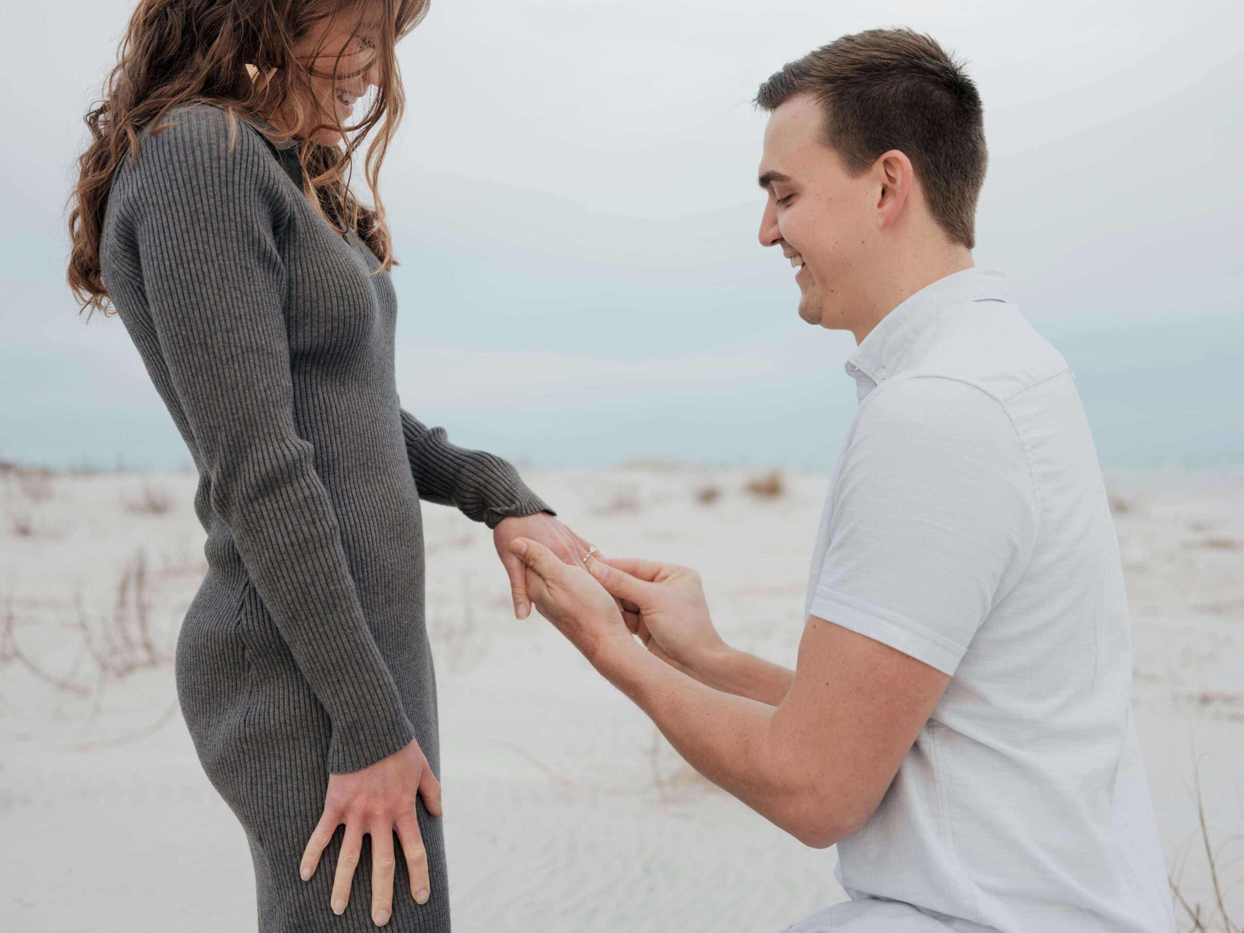 man putting an engagement ring on a woman's hand