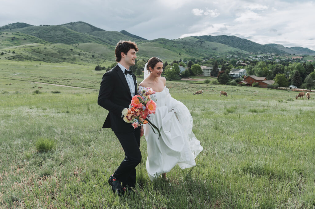 Newly wed couple walking through a field